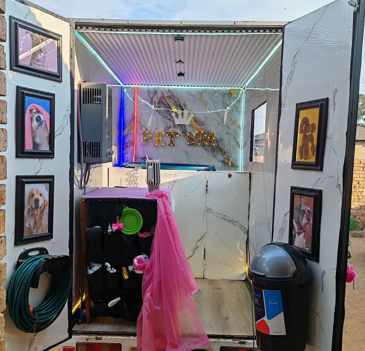 Maison De Paws mobile pet spa interior showing the PET SPA signage, marble-look wall and framed pet portraits